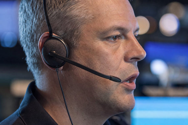 Close-up of a dispatcher speaking into the boom microphone of a single-ear headset